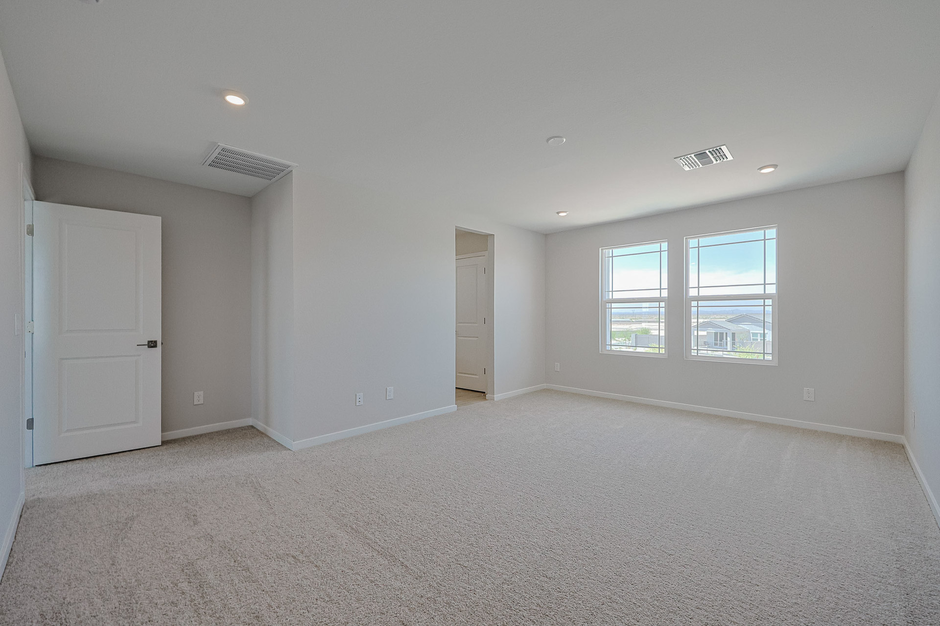 A room with a carpet and windows.