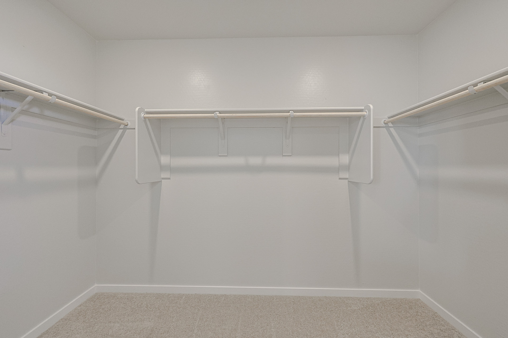 A white wall with a metal bar.
