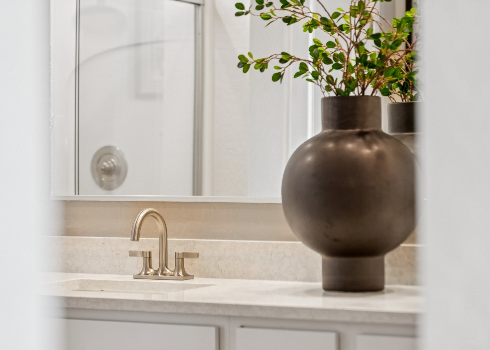 photo up close of  bathroom brushed nickel hardware, marble counters, shower, and model home decor editorial lifestyle shot at the lakes at rancho el dorado model home in maricopa, AZ with close access to the 347.