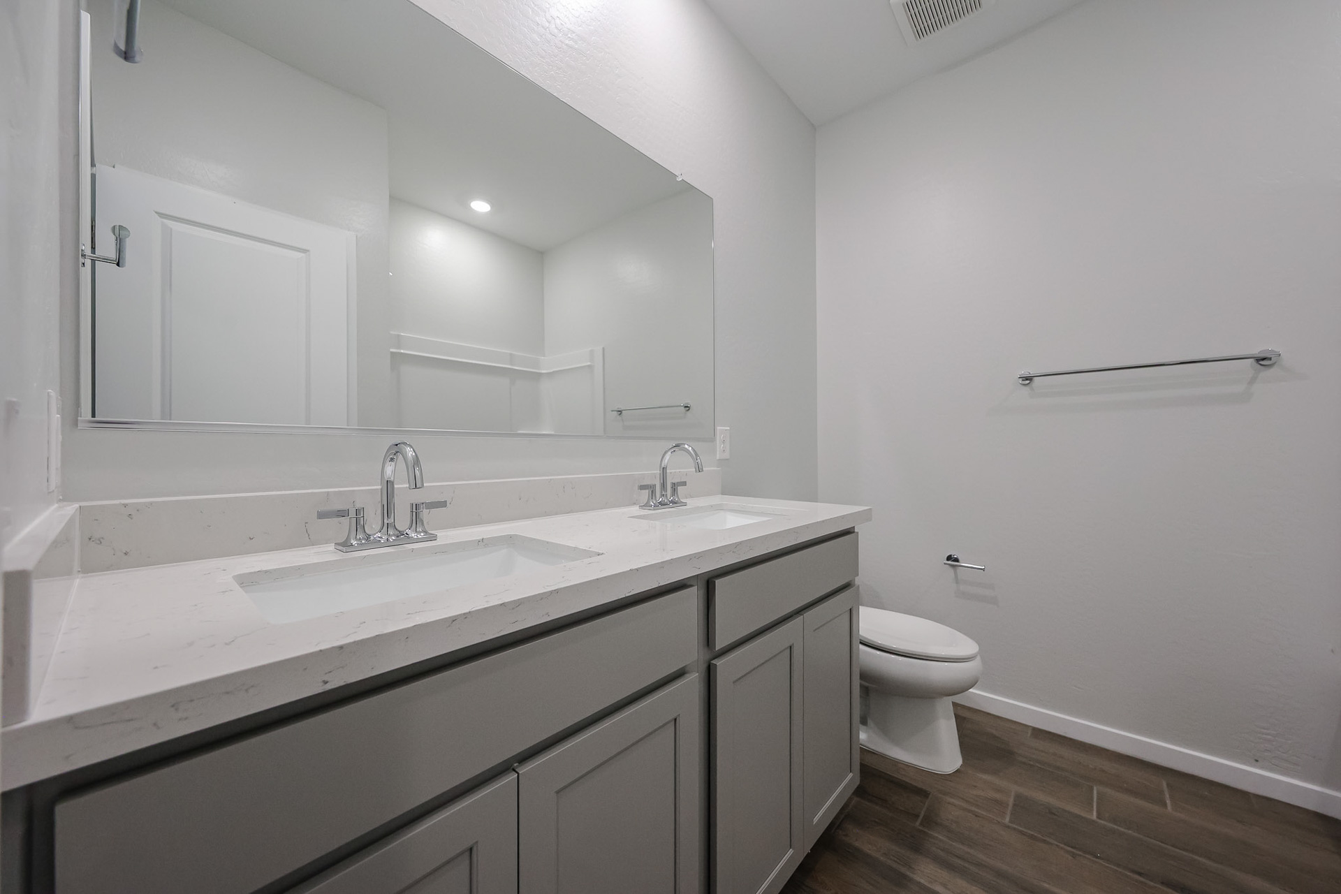 A bathroom with a sink toilet and mirror.