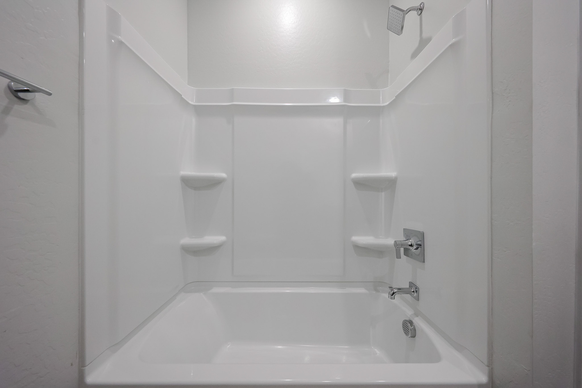 A bathroom with a tub toilet and urinal.