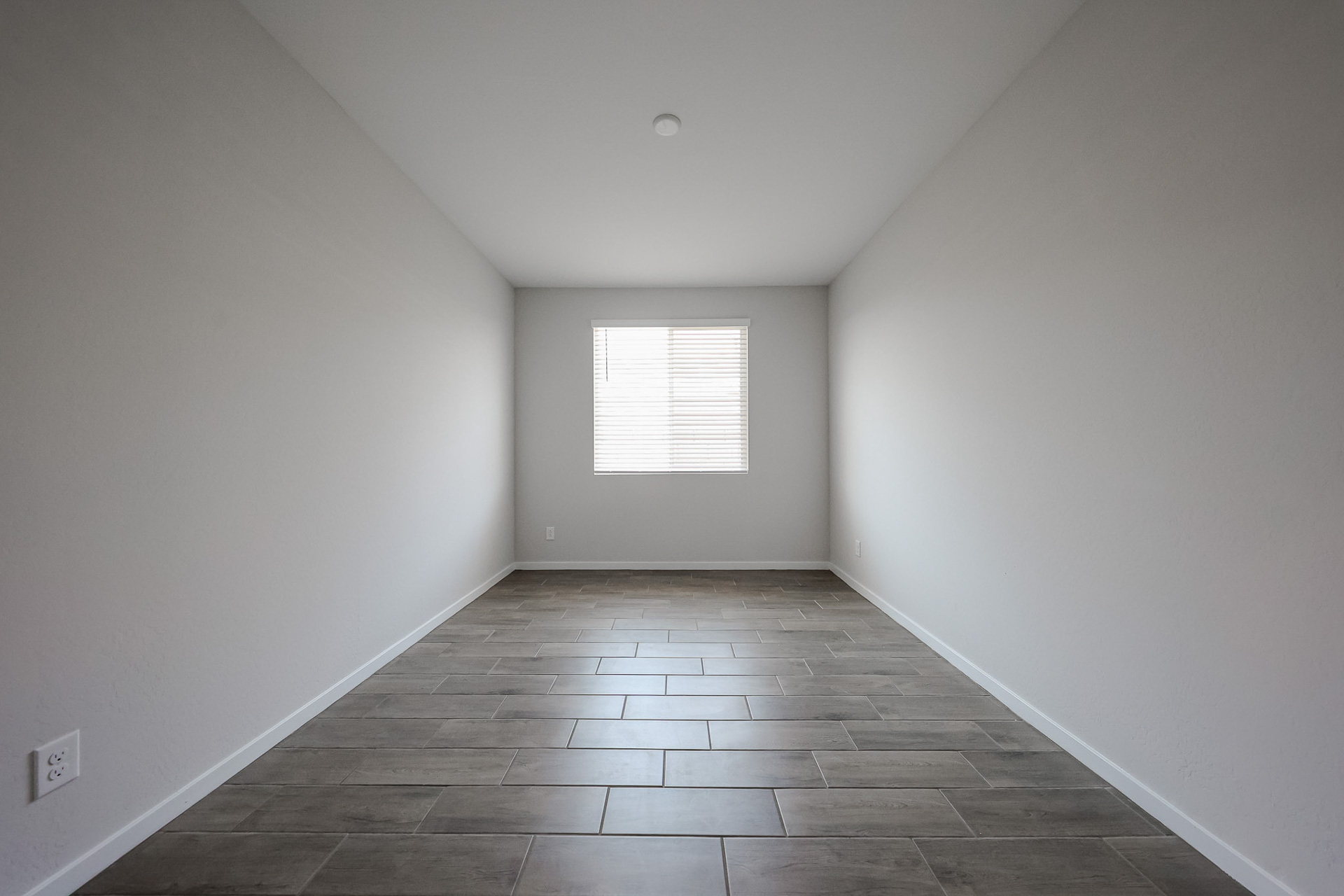 A room with a tile floor and a window.