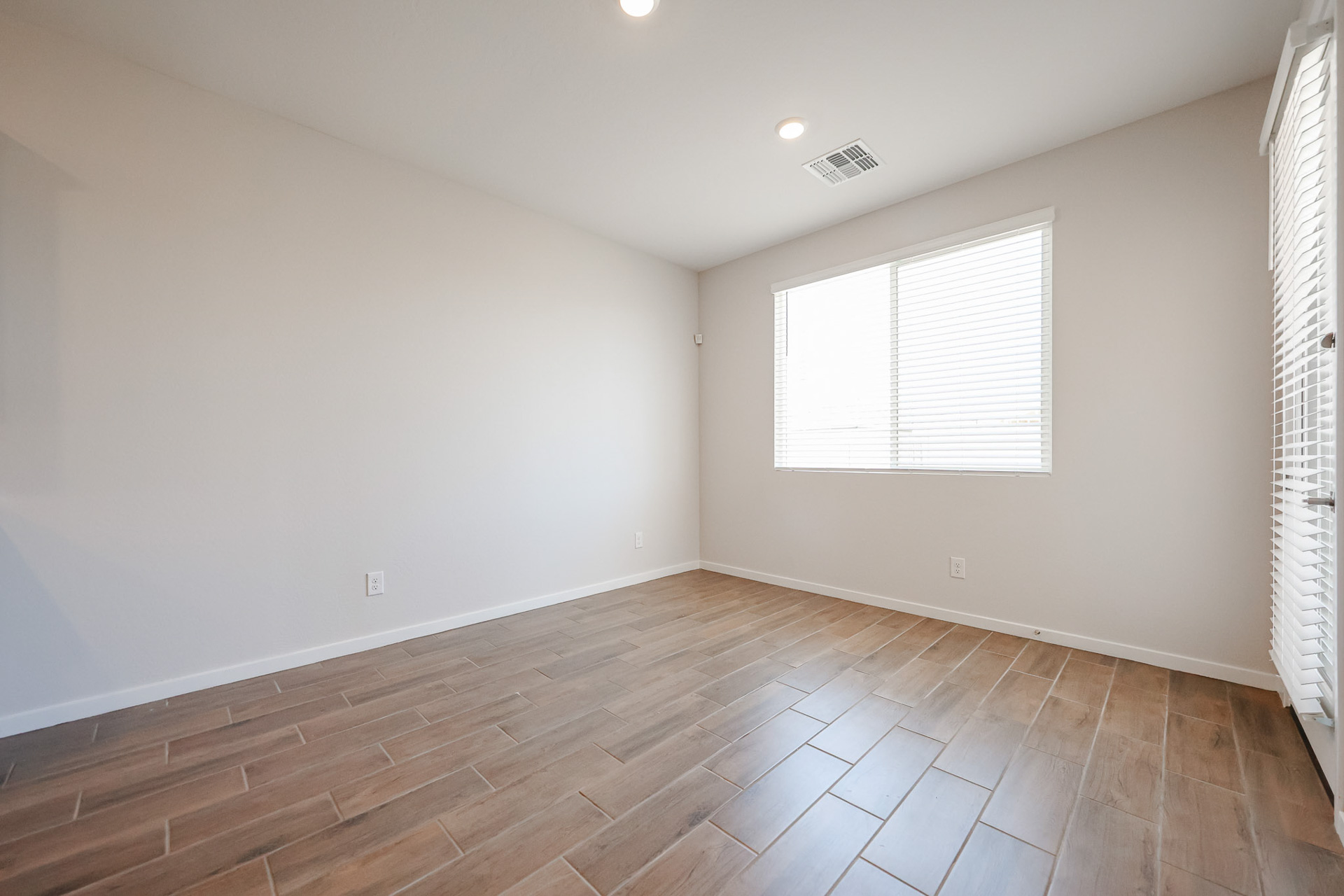 A room with a wood floor and white walls.