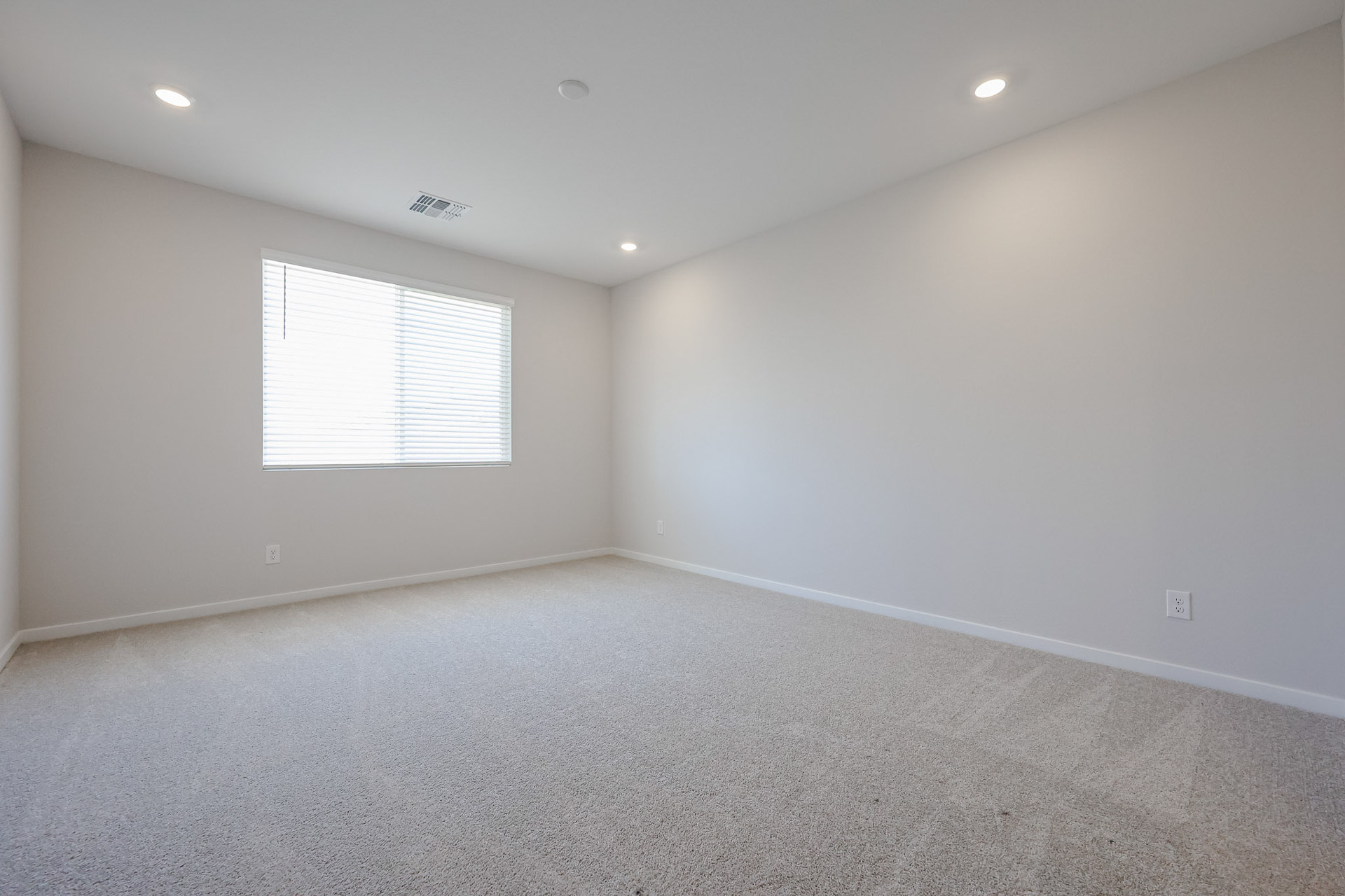 A room with a carpet and a window.