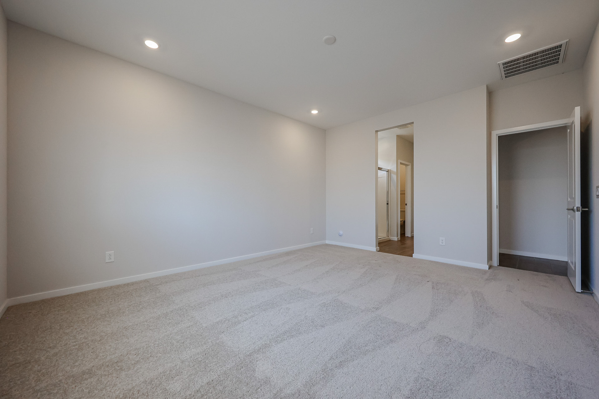 A room with a carpet and a door.