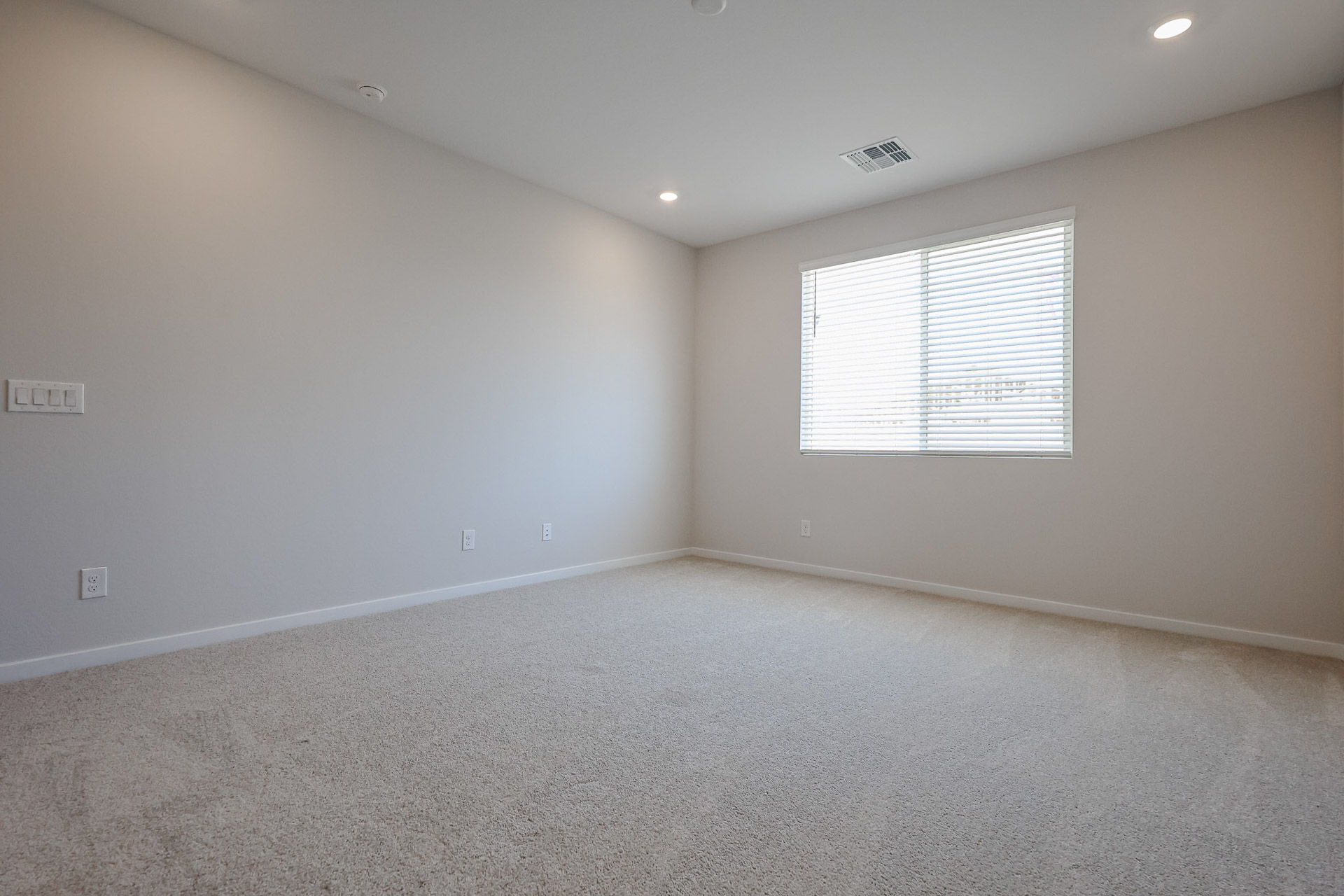A room with a window and carpet.