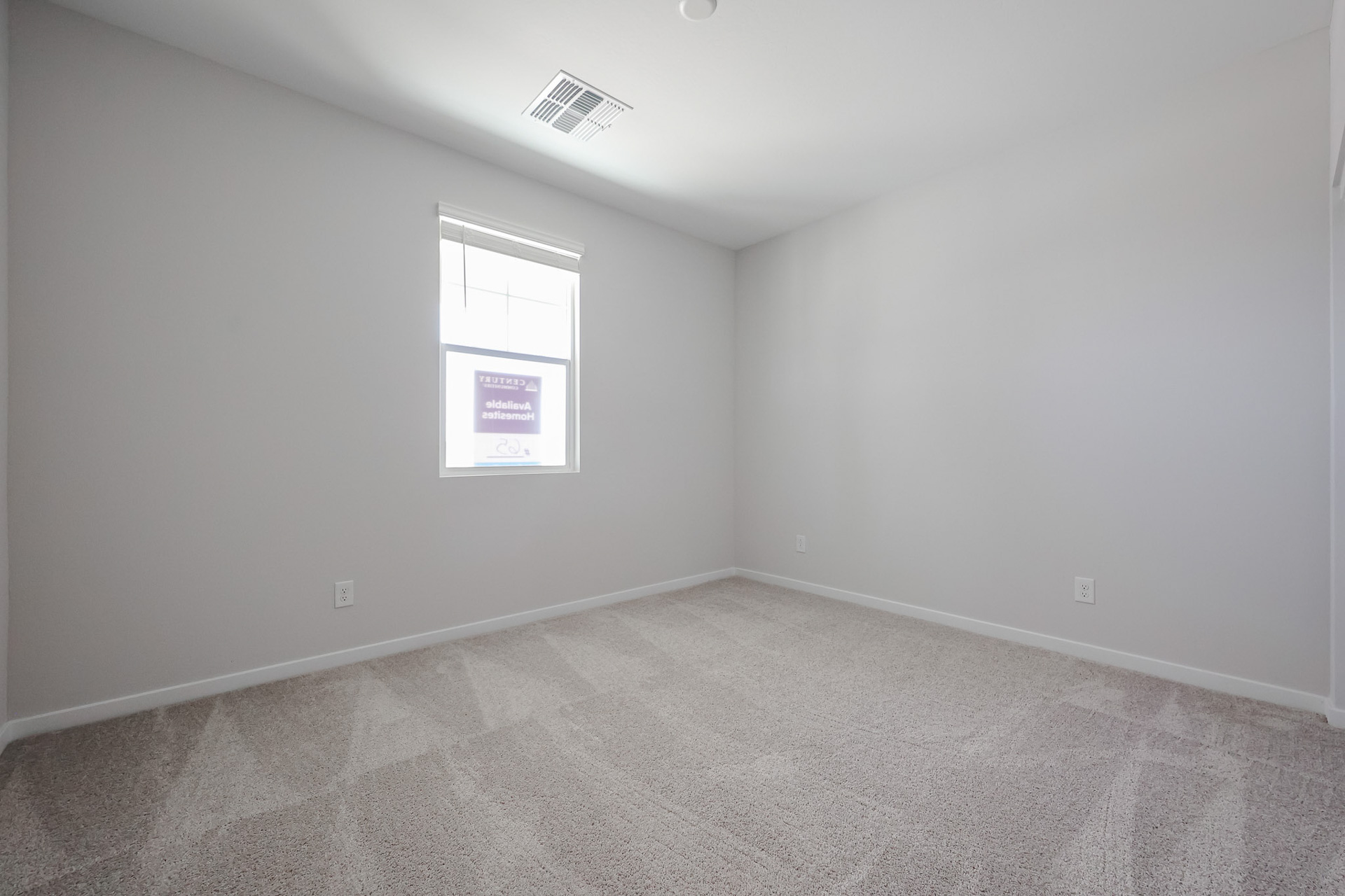 A room with a window and a rug.