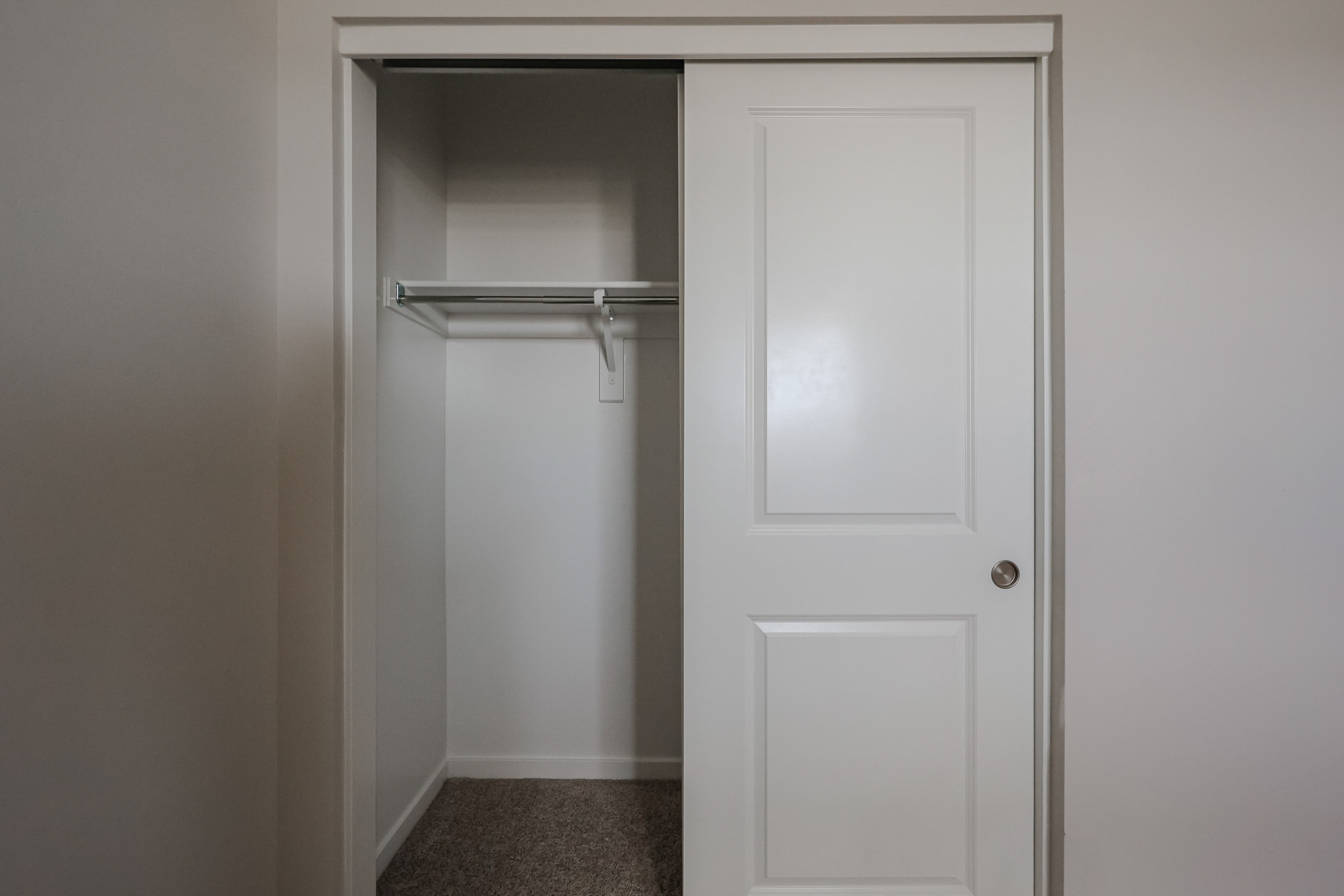 A white door with a metal bar.
