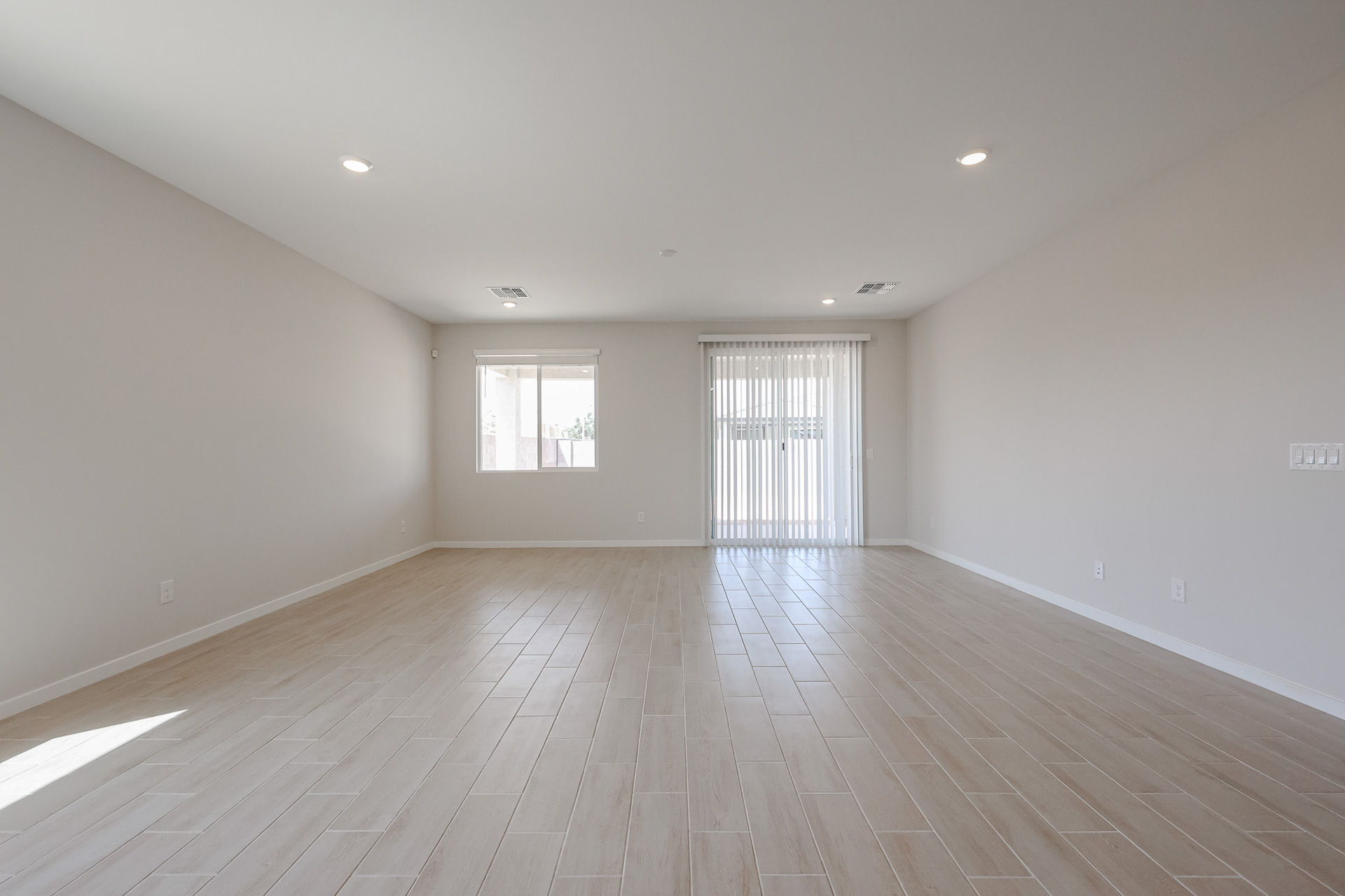 A room with a wood floor and a wood floor with a window.