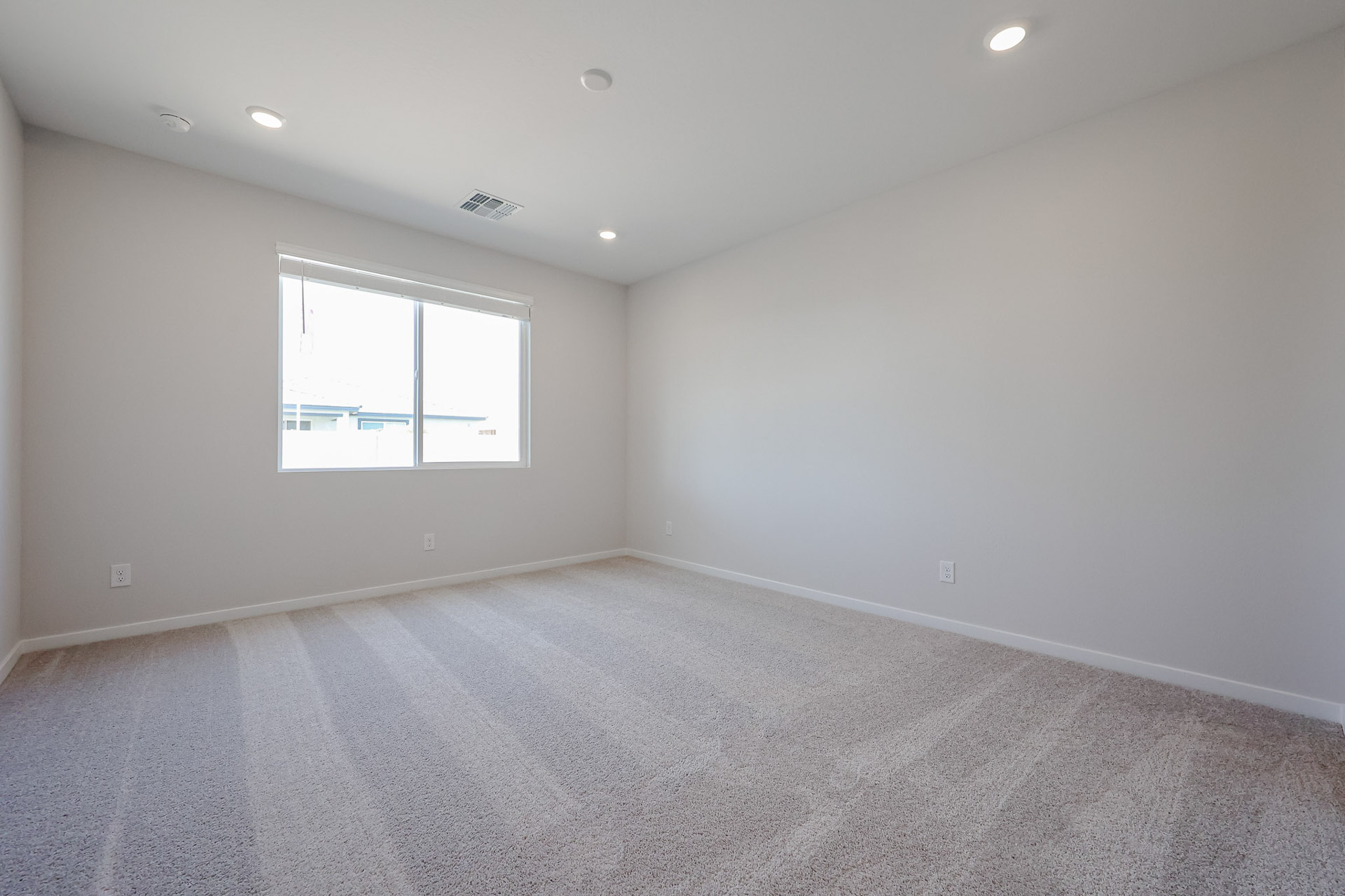 A room with a window and carpet.