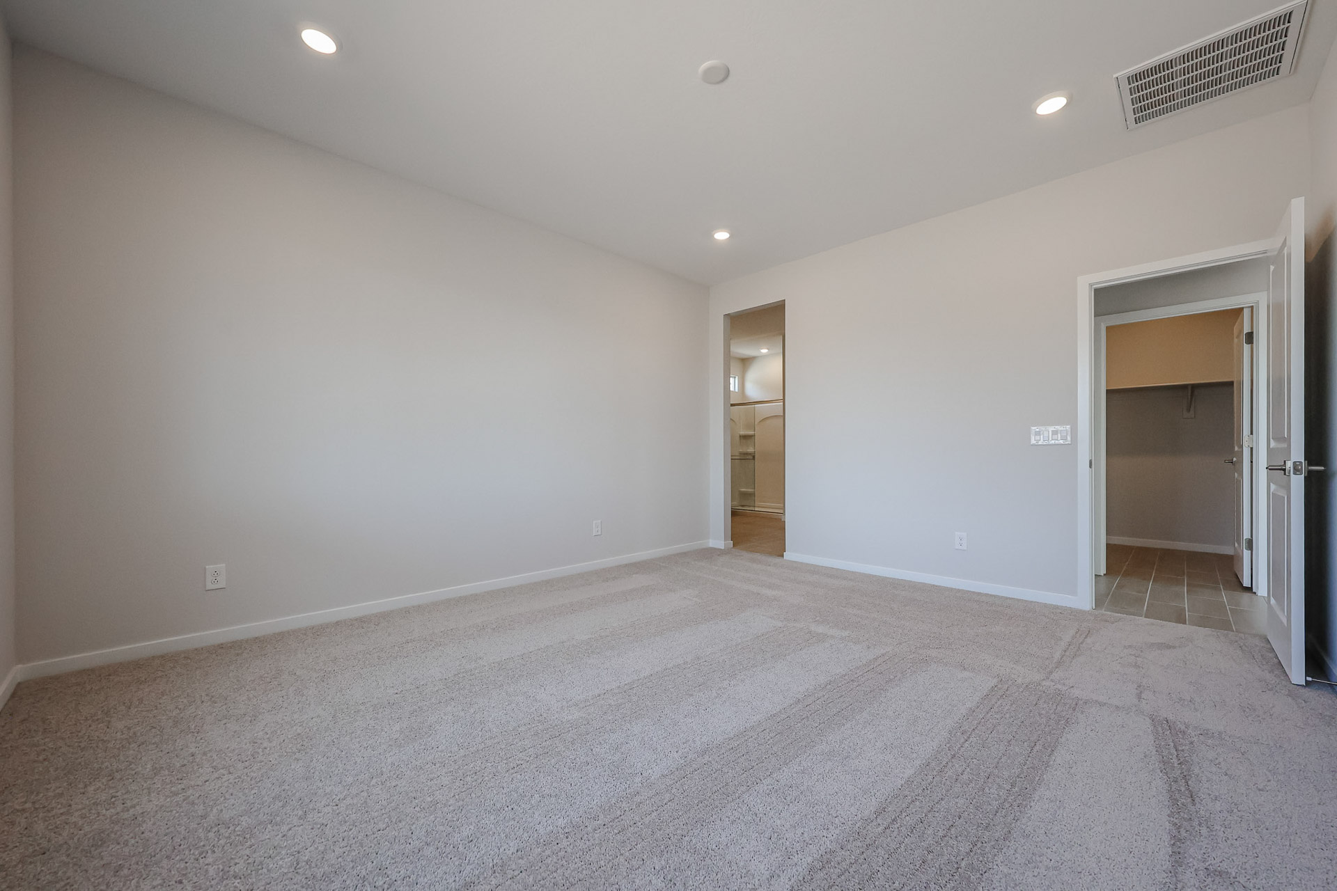 A room with a carpet and a door.