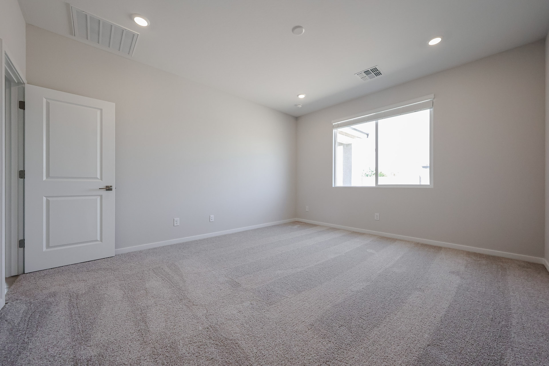 A room with a carpet and a window.