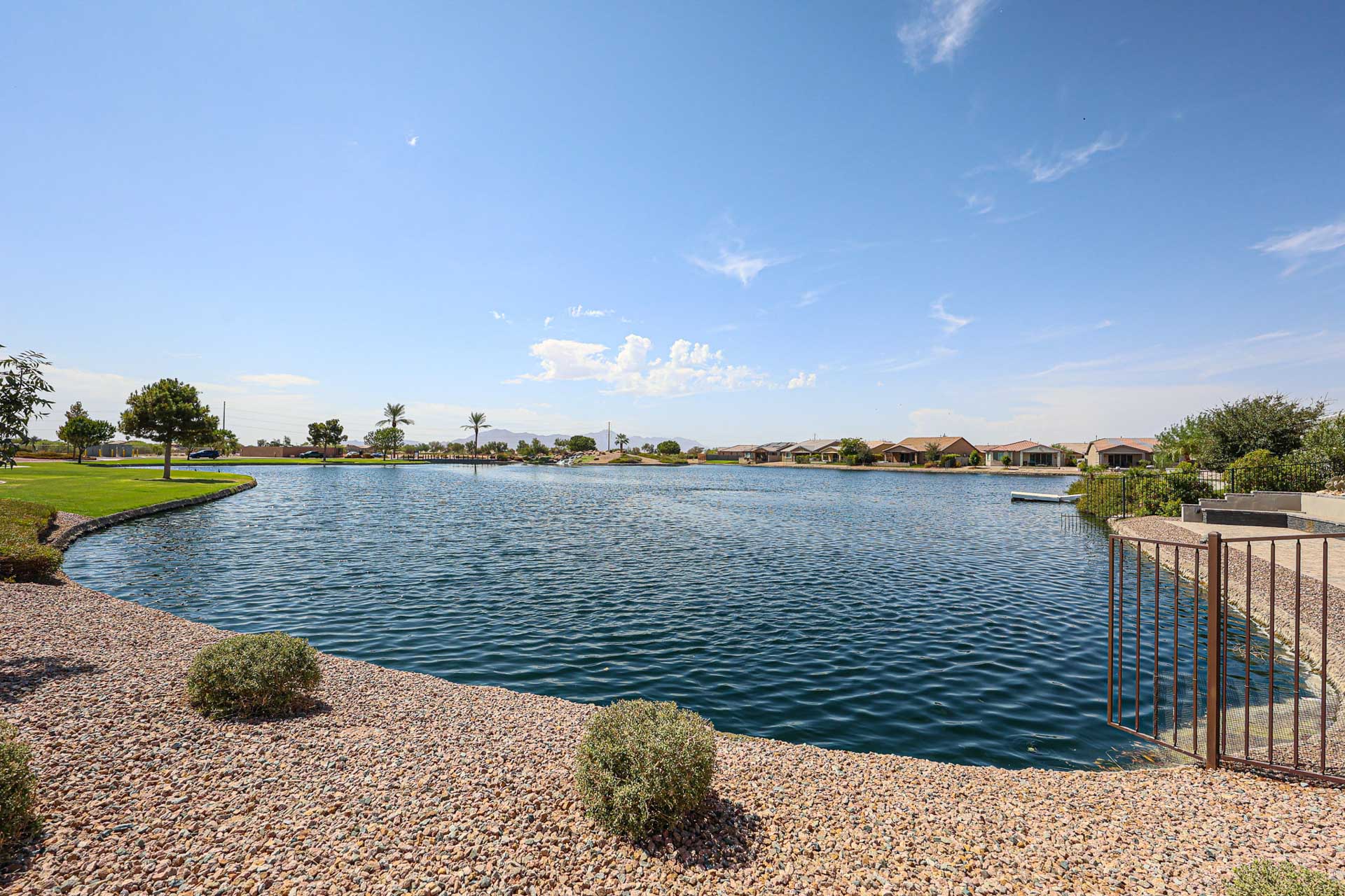 A body of water with a fence and trees around it.