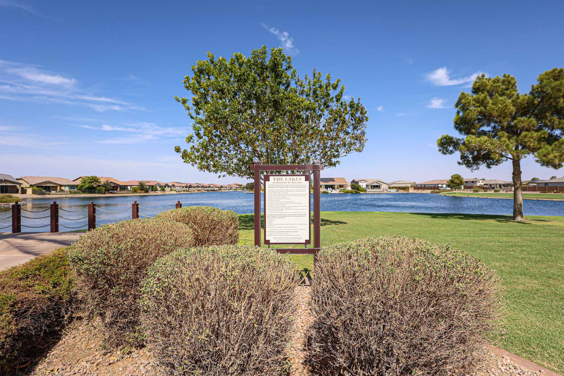 A sign on a path by a body of water.