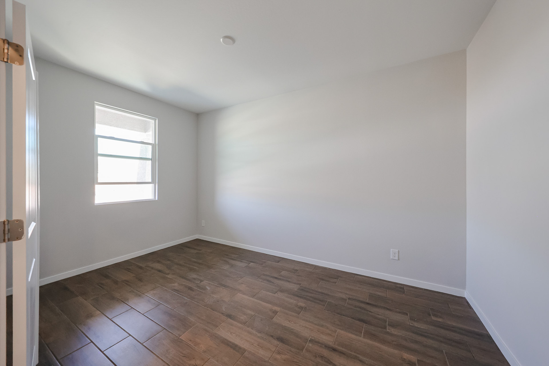 A room with a wood floor and a window.