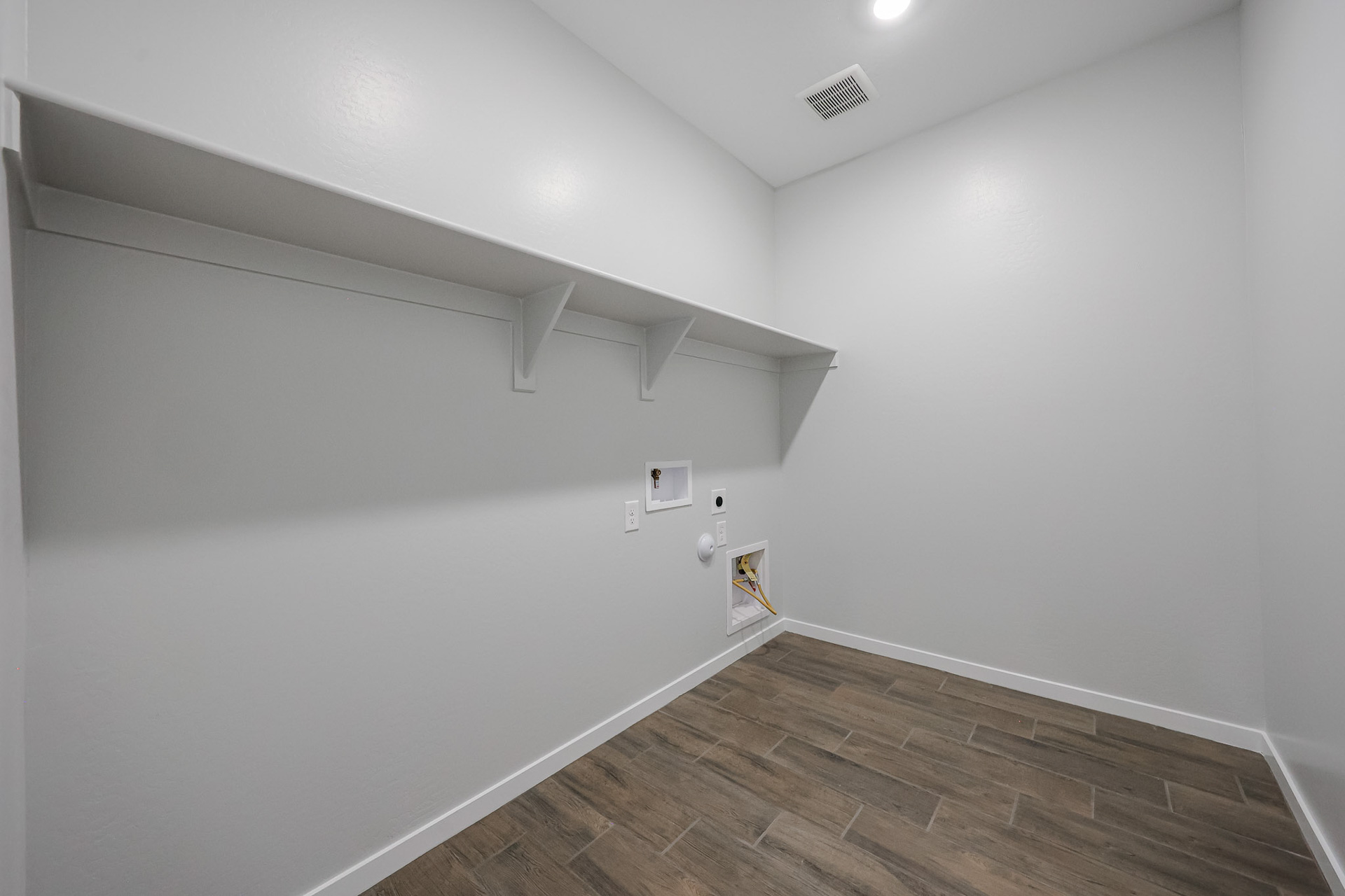 A room with a wood floor and white walls.