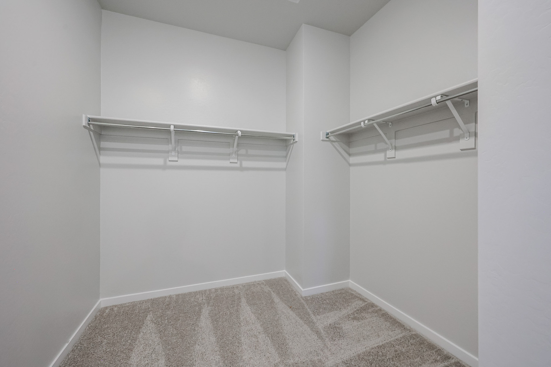 A room with a carpet and a metal bar.