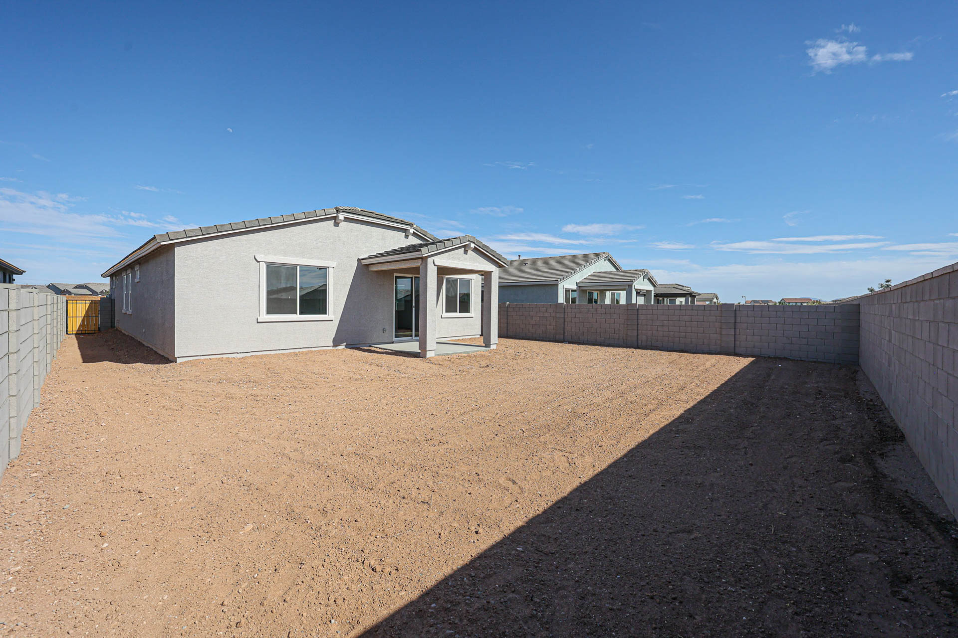 A dirt road with buildings on the side.