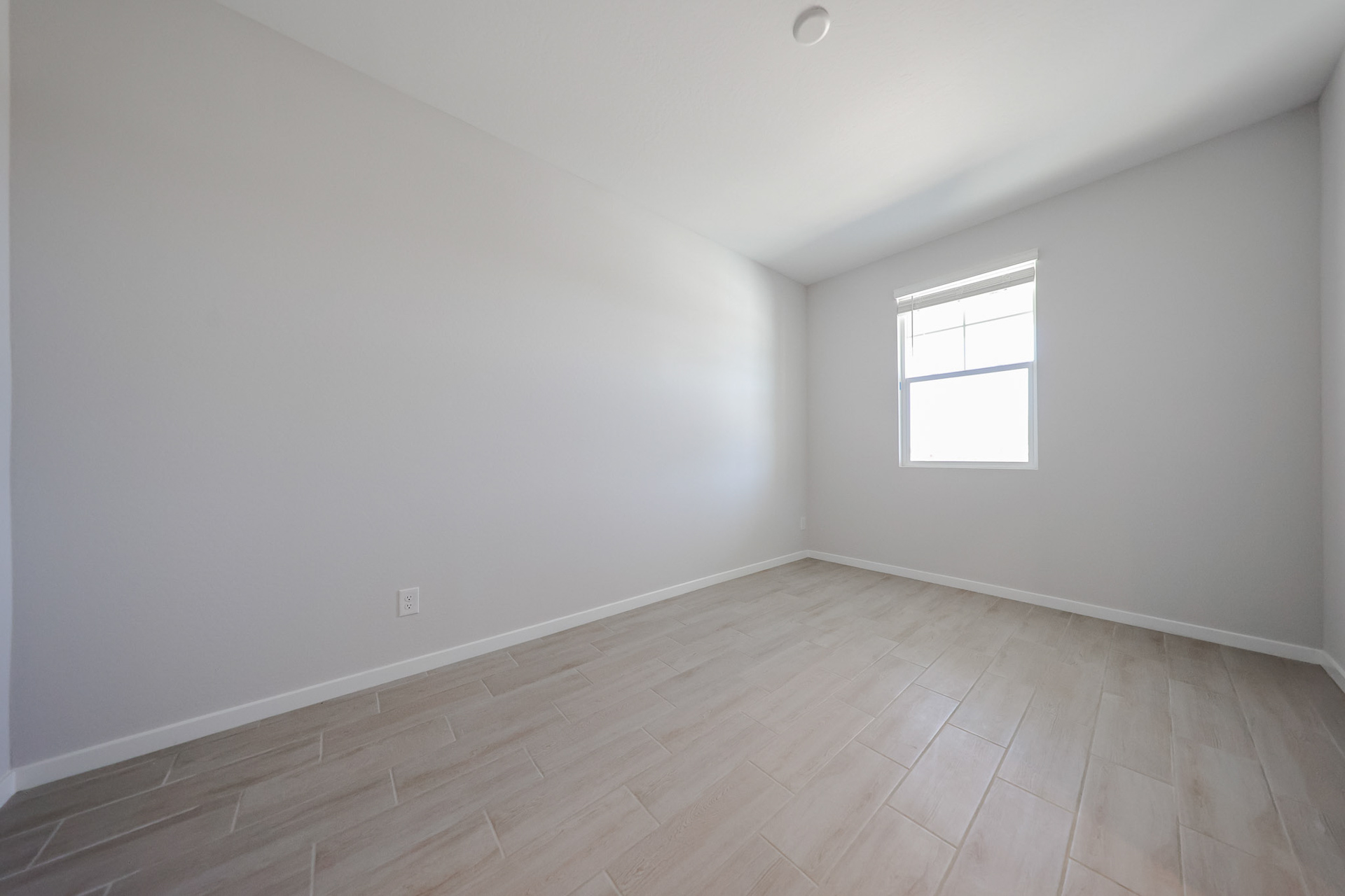 A room with a wood floor and windows.