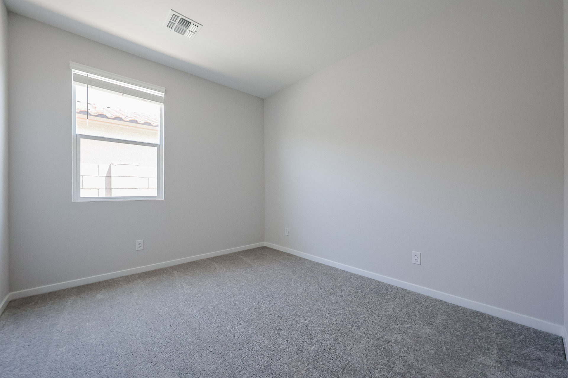 A room with a window and a carpet.