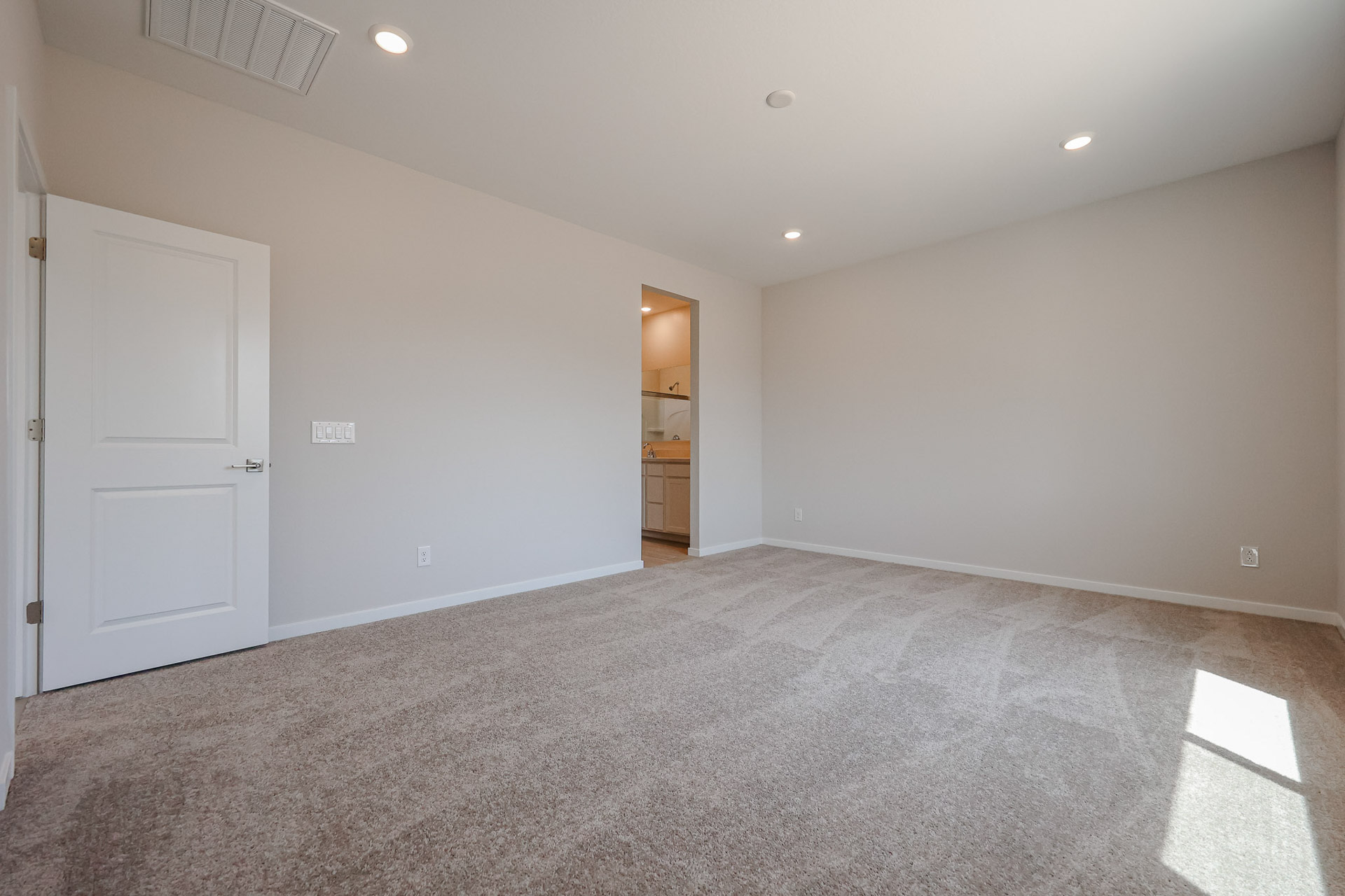 A room with a carpet and a door.