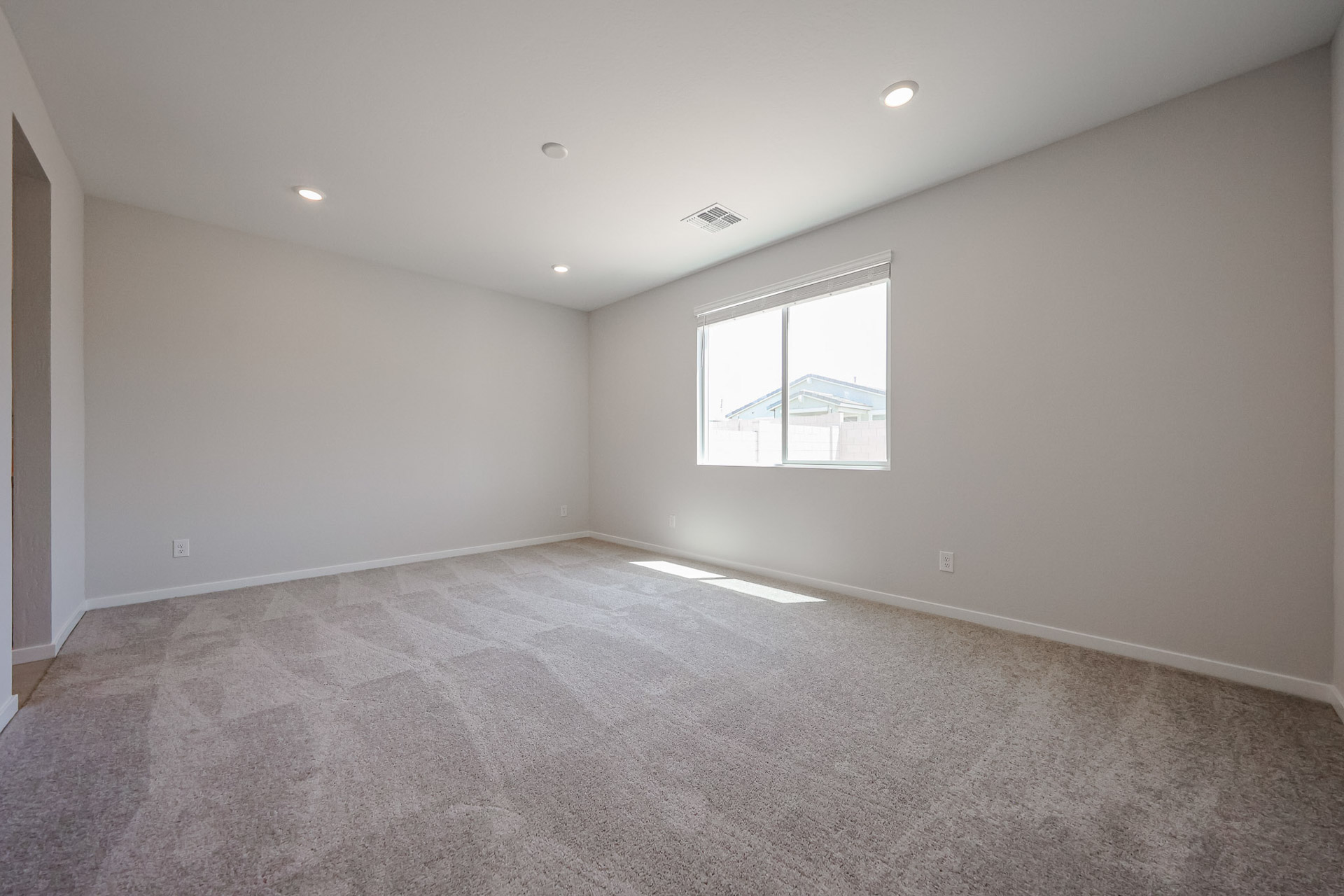 A room with a window and carpet.