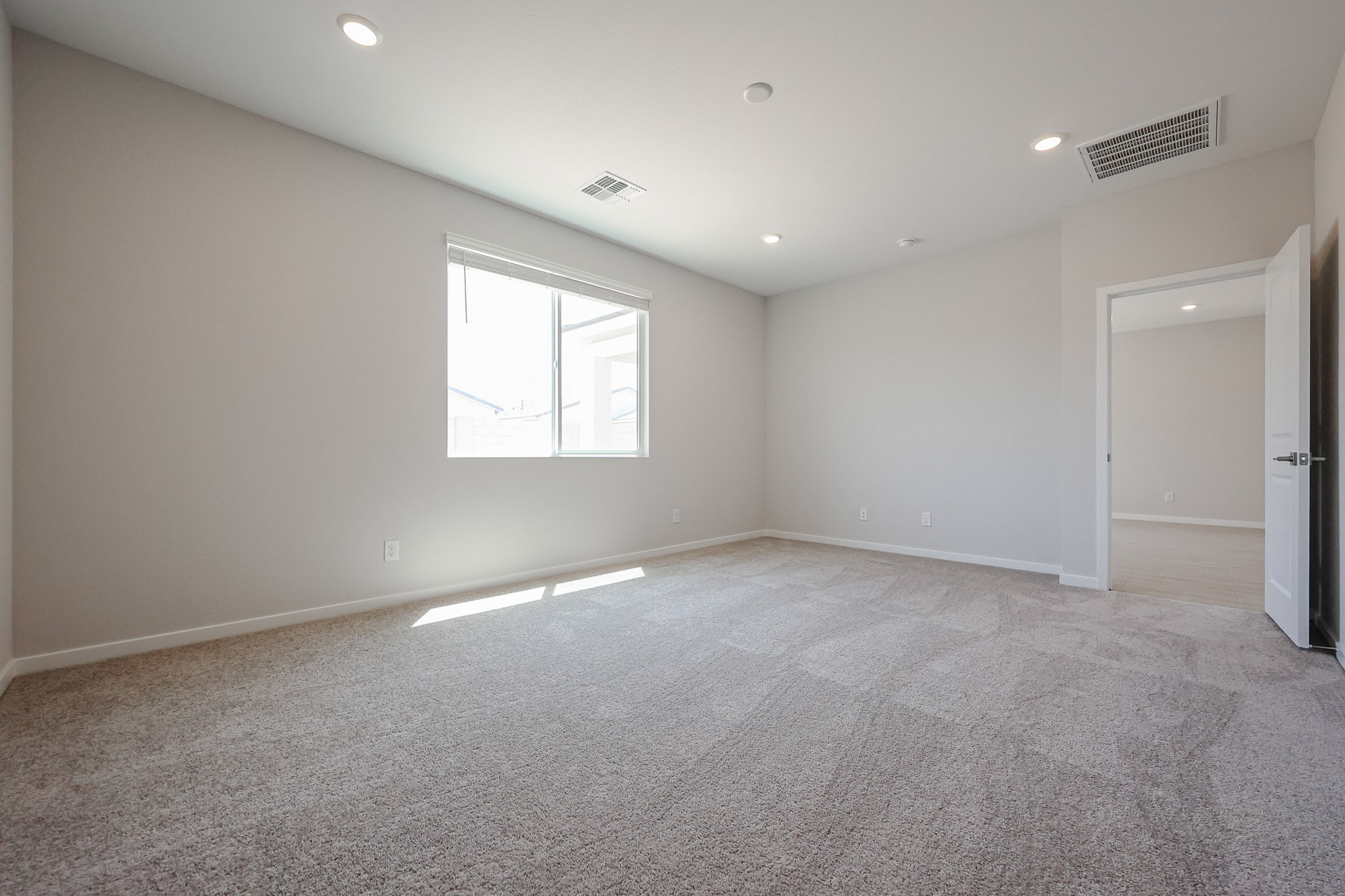 A room with a carpet and a window.