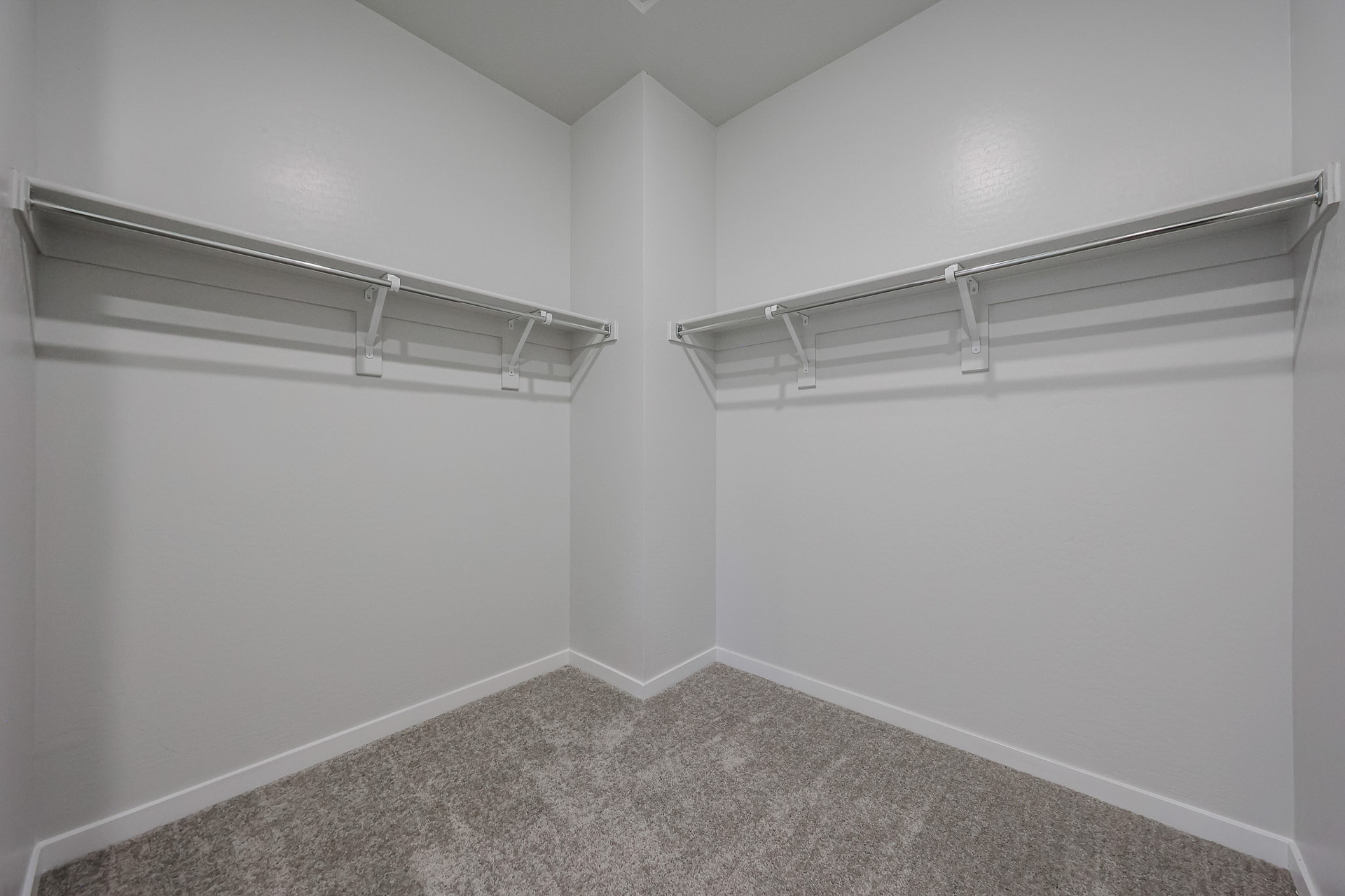 A white wall with a metal bar.