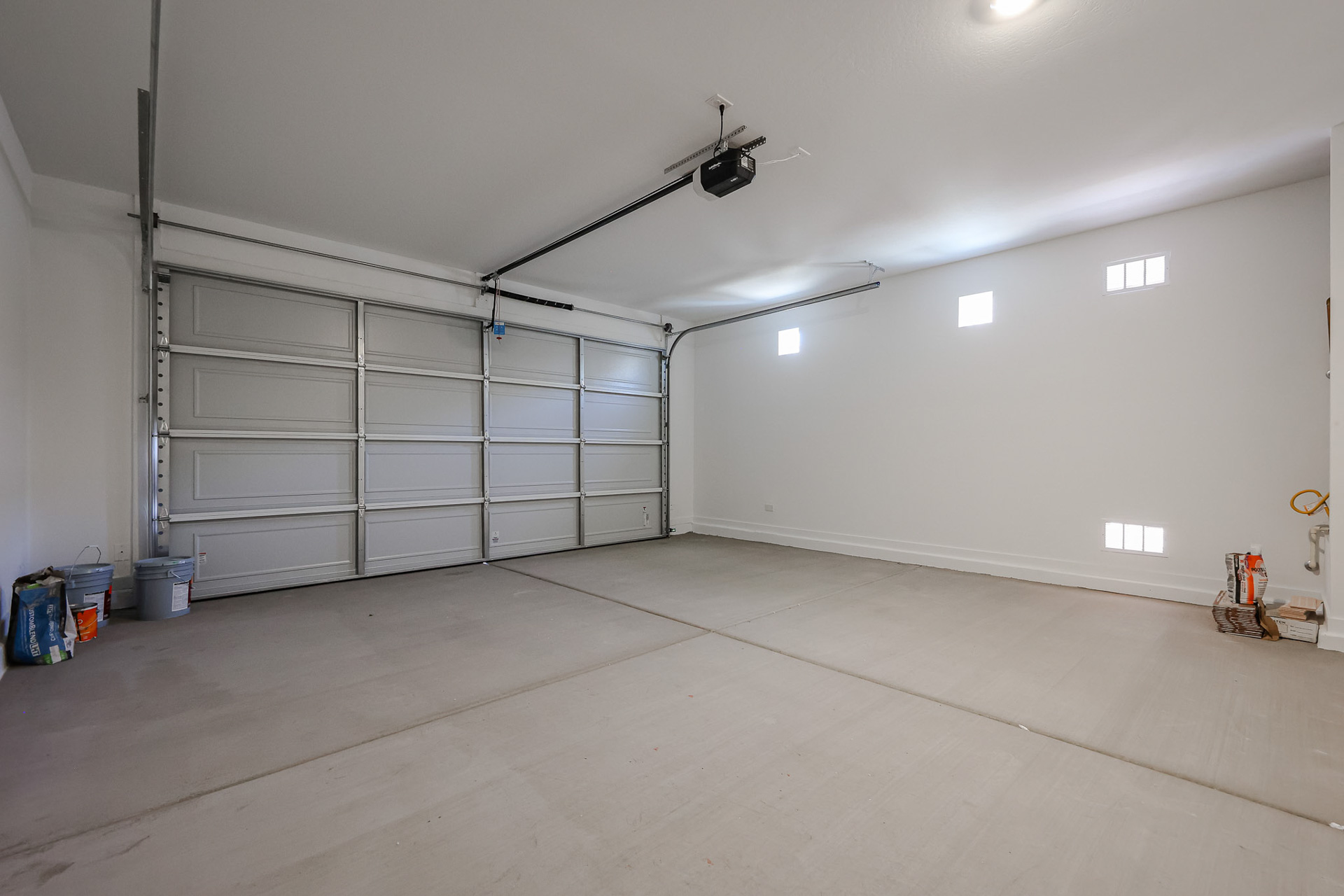 A room with a large white wall and a metal gate.