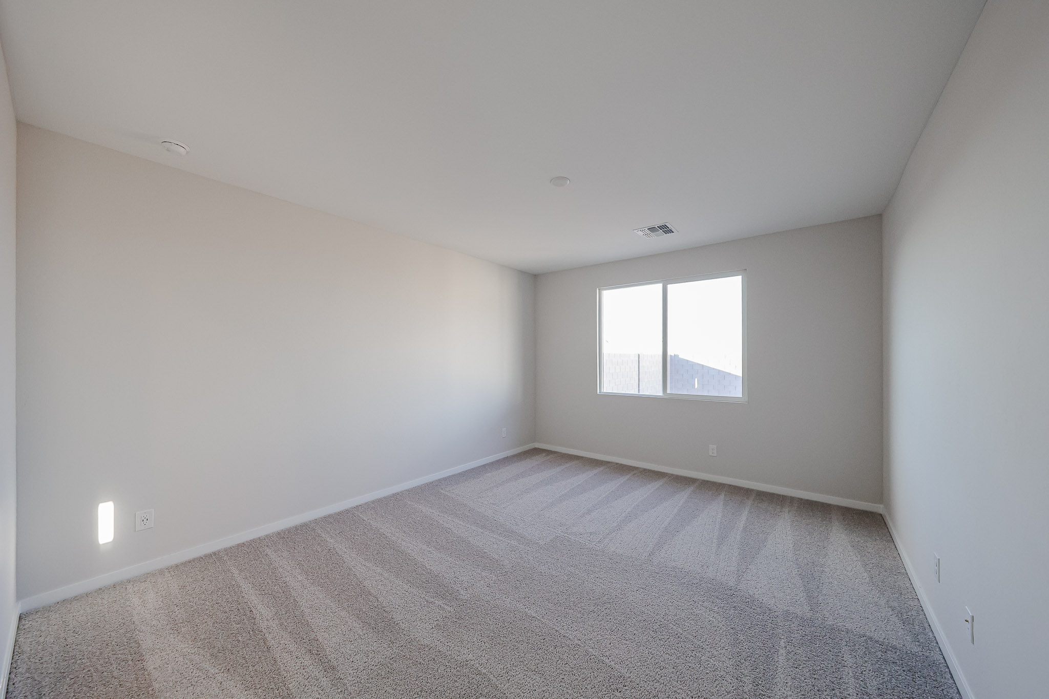 A room with a carpet and a window.