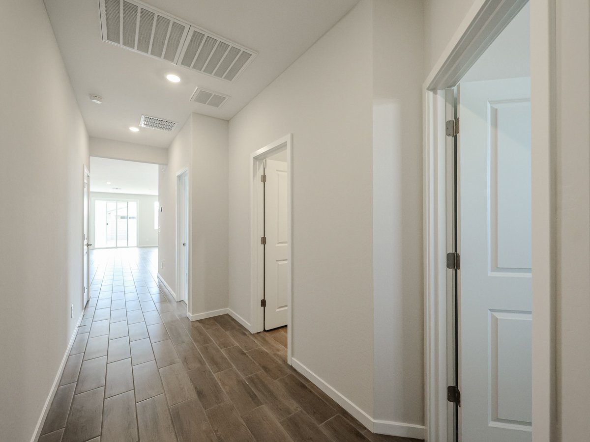 A long hallway with white doors.