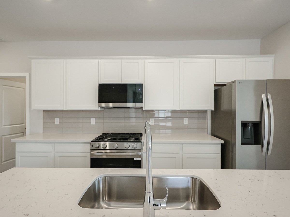 A kitchen with white cabinets.