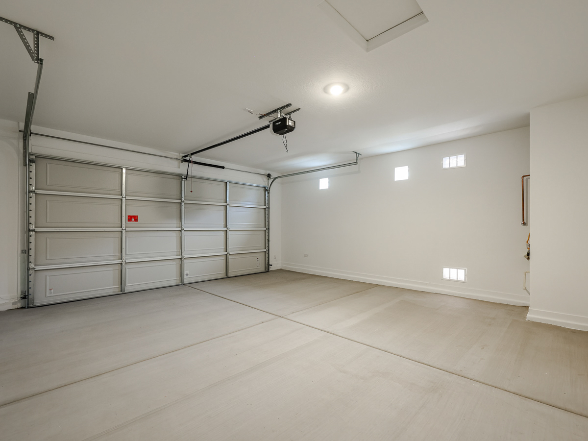 A room with a white wall and a metal gate.
