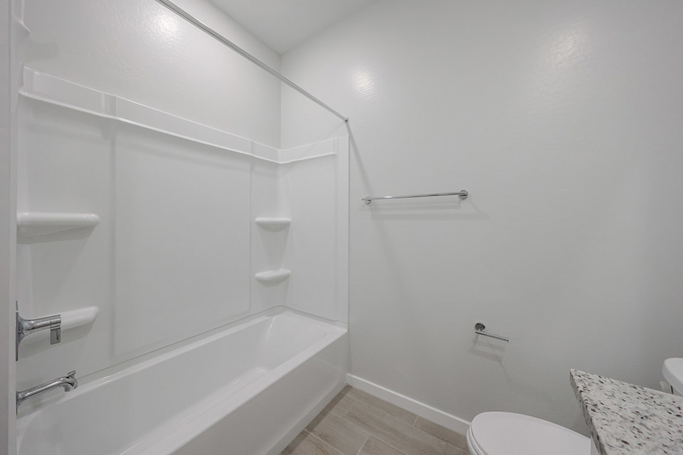 A bathroom with a bathtub and toilet.