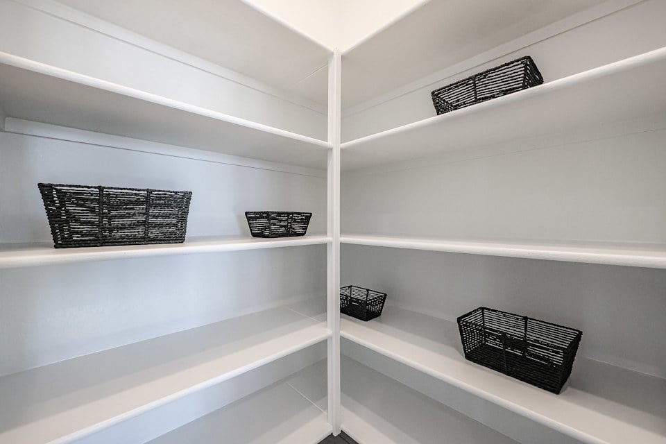 A white shelf with baskets and baskets.