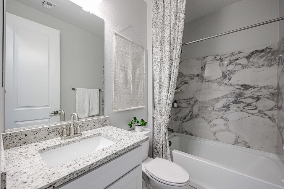 A bathroom with a tub sink and toilet.