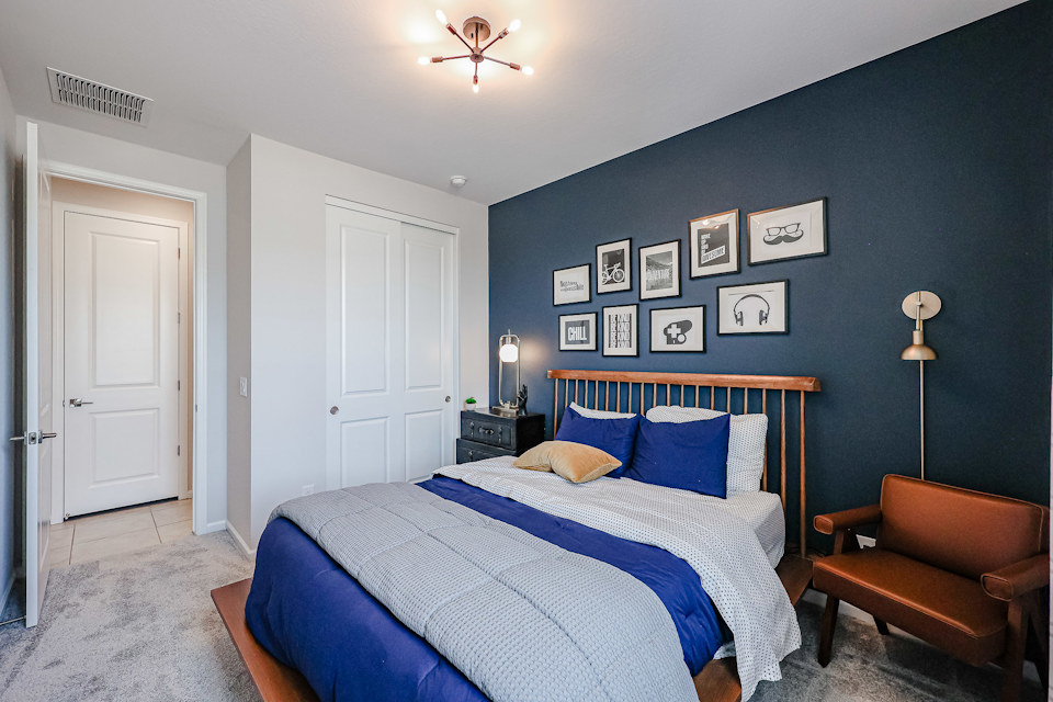 A bedroom with a bed and a chair.