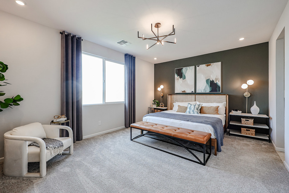 A bedroom with a bed and a chair.