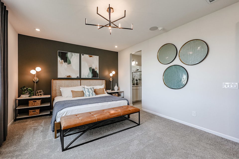 A bedroom with a bed and a mirror.