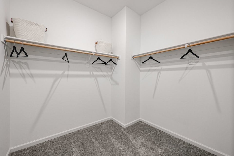 A white room with a bed and a chair.