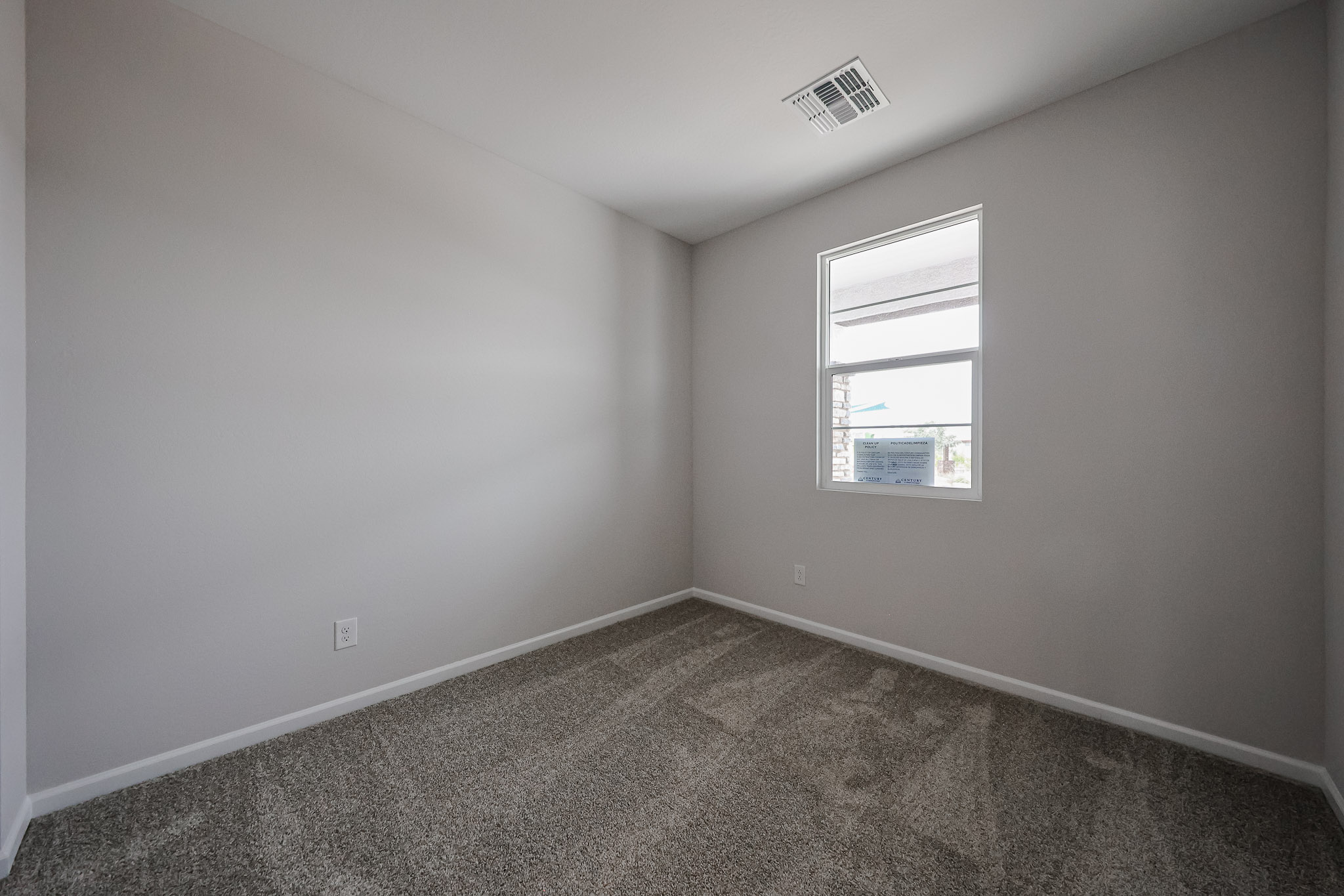 A room with a carpet and a window.