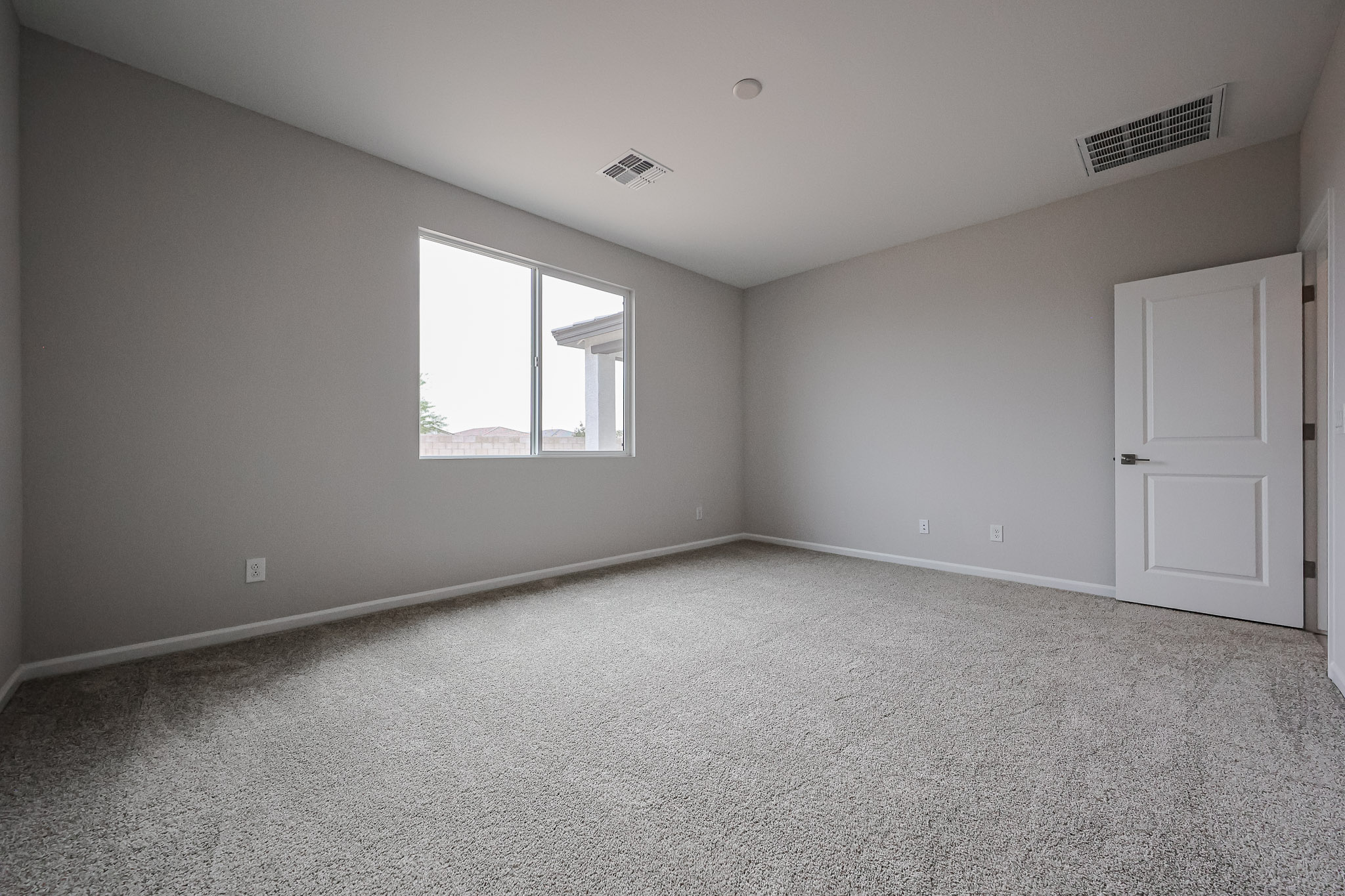 A room with a window and carpet.
