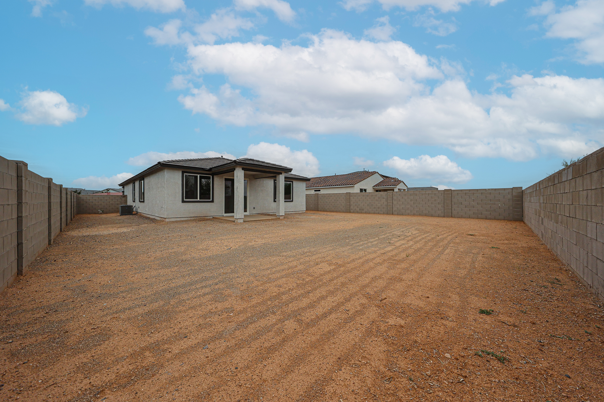 A dirt field with a building in the background.
