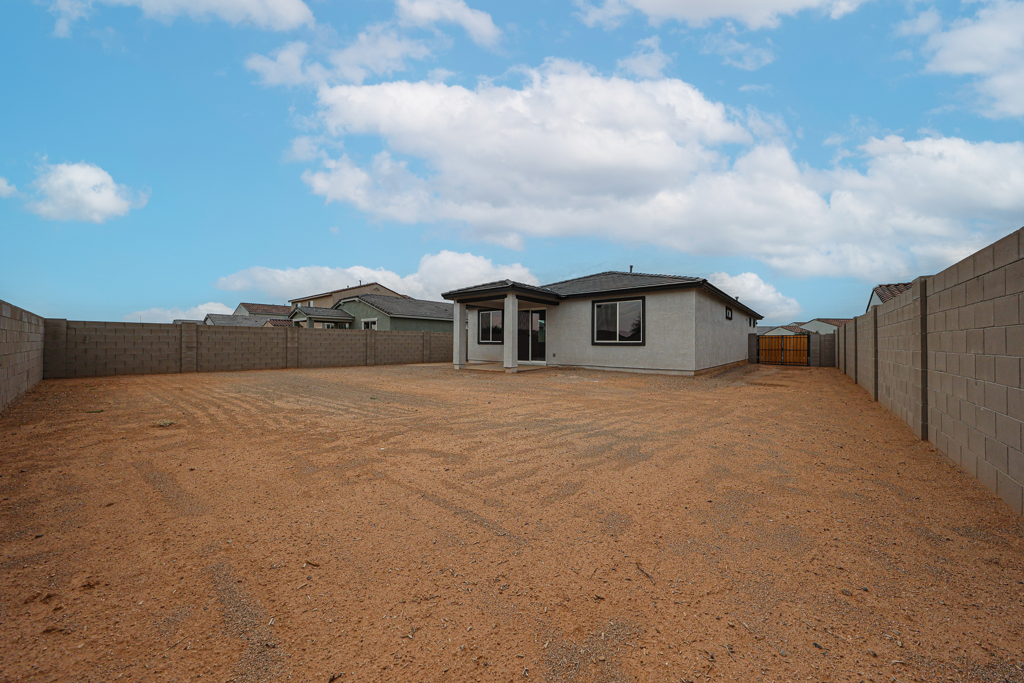 A dirt road with buildings on the side.