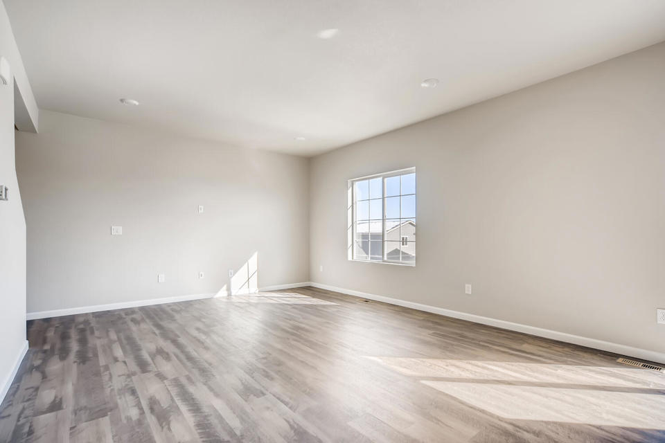 A room with a wood floor and a window.