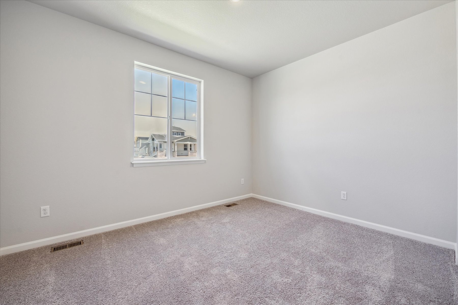 A room with a window and a carpet.
