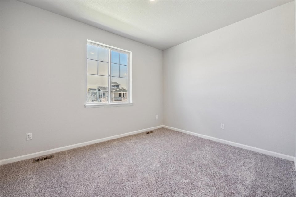 A room with a window and a carpet.