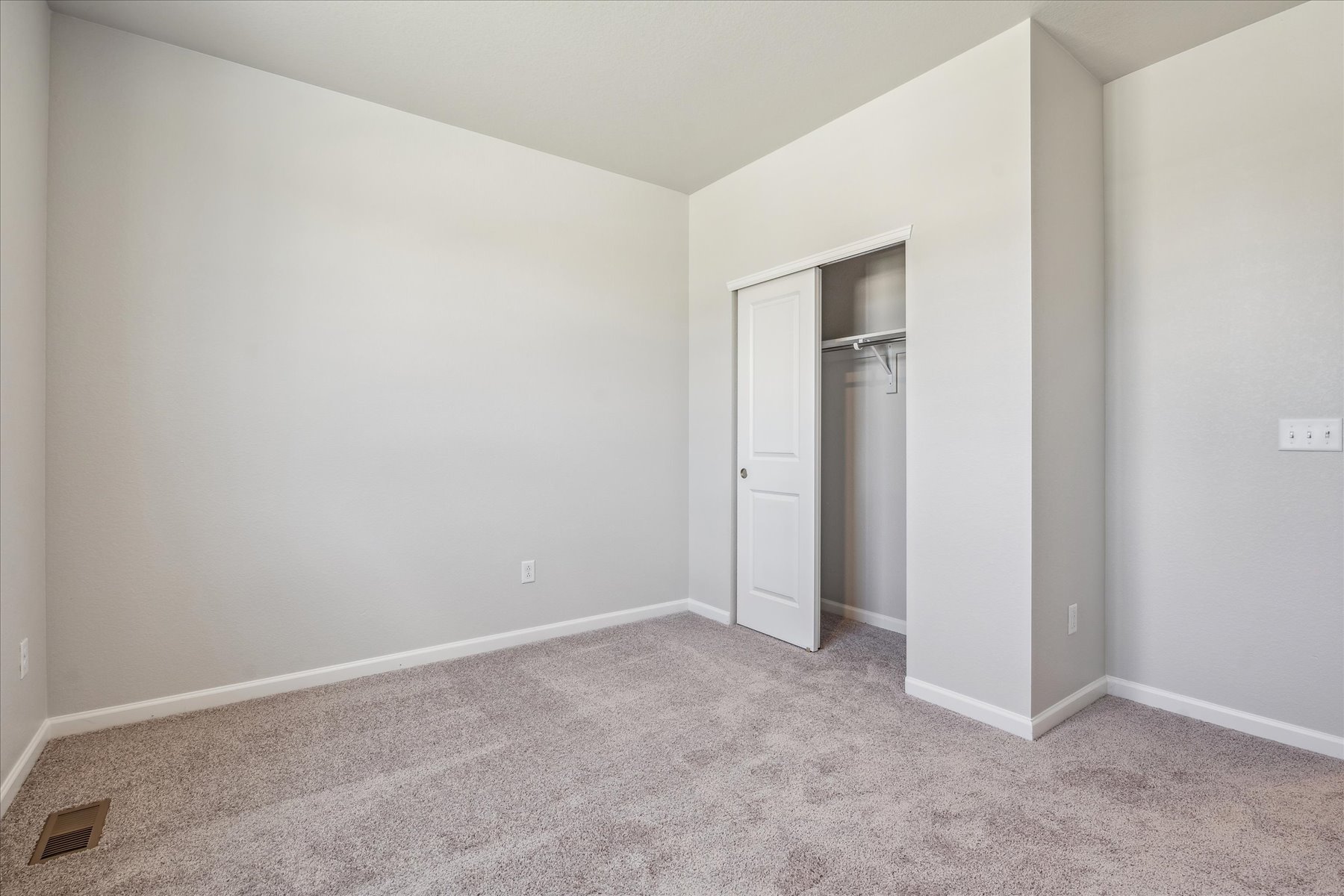 A hallway with a door and a mirror.