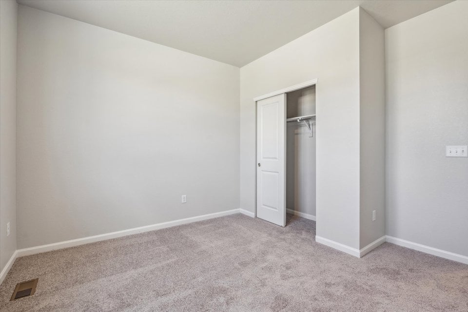 A hallway with a door and a mirror.