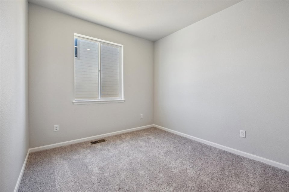 A room with a window and a carpet.